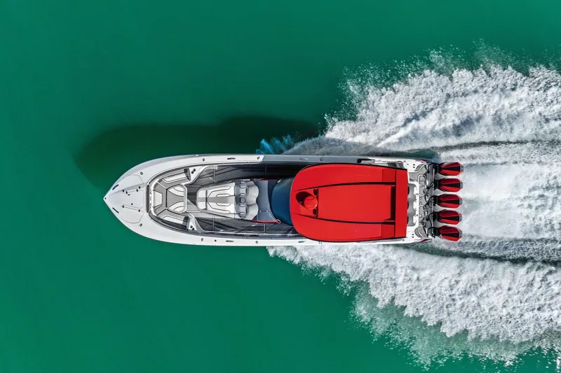Slide: The Image of Aerial view of 2024 MTI V42 speedboat with red accents on turquoise water. - 15