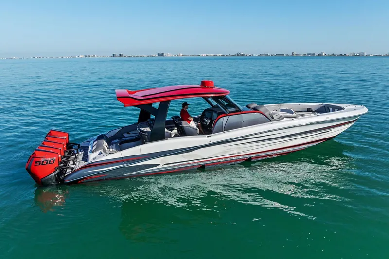 Slide: The Image of 2024 MTI V42 boat with red accents and triple outboard engines on calm water. - 21