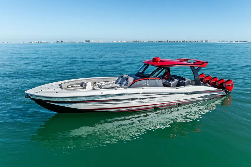 Slide: The Image of 2024 MTI V42 boat with red accents on calm blue water. - 3