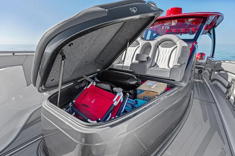 Slide: The Image of 2024 MTI V42 boat with open storage compartment, revealing packed items and seating area. - 54