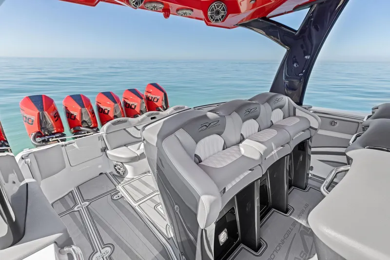 Slide: The Image of 2024 MTI V42 boat interior with red engines, luxurious seating, and ocean backdrop. - 73