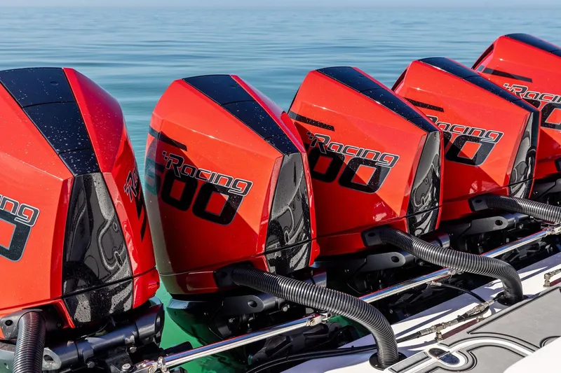 Slide: The Image of Red racing boat engines on MTI V42, 2024 model, lined up on calm water. - 82