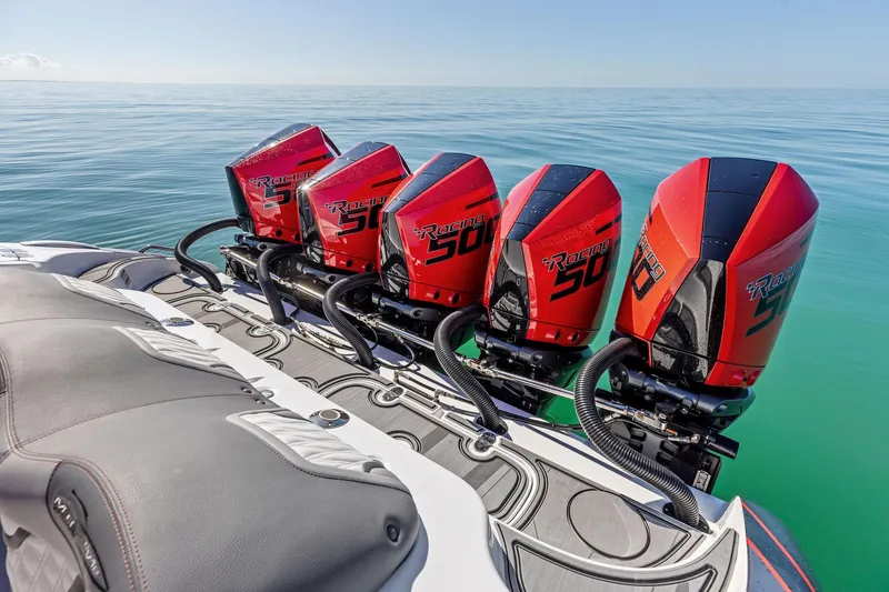 Slide: The Image of 2024 MTI V42 boat with four powerful red Racing 500 engines on calm water. - 85