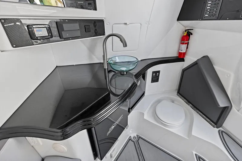Slide: The Image of Modern MTI V42 boat interior with sleek black countertop, glass sink, and fire extinguisher. - 91