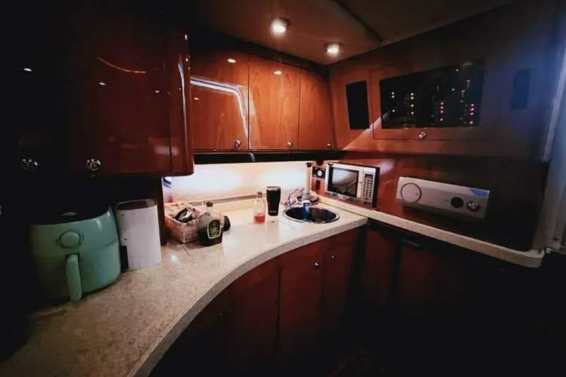 Slide: The Image of 2007 Regal Commodore 4460 yacht kitchen with wooden cabinets and modern appliances. - 14