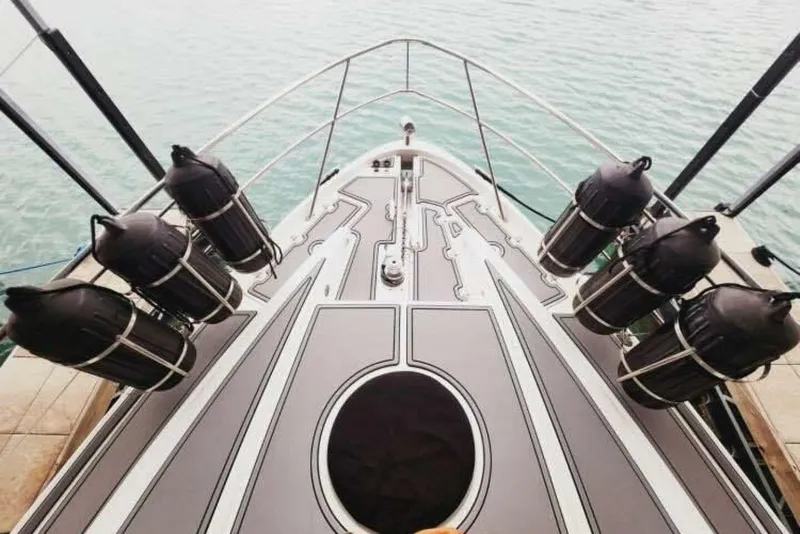 Slide: The Image of Bow of 2007 Regal Commodore 4460 yacht with fenders, docked on calm water. - 8