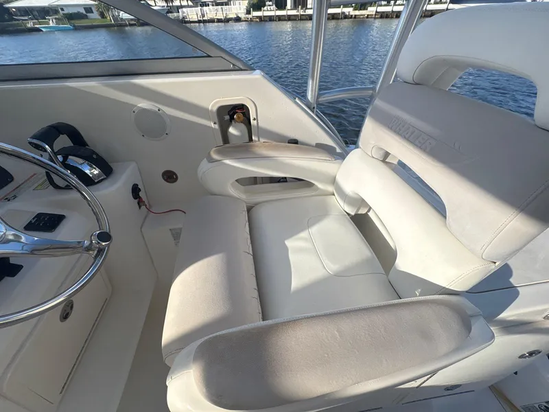 Slide: The Image of 2007 Boston Whaler 305 Conquest helm seat and steering wheel, docked by the water. - 10
