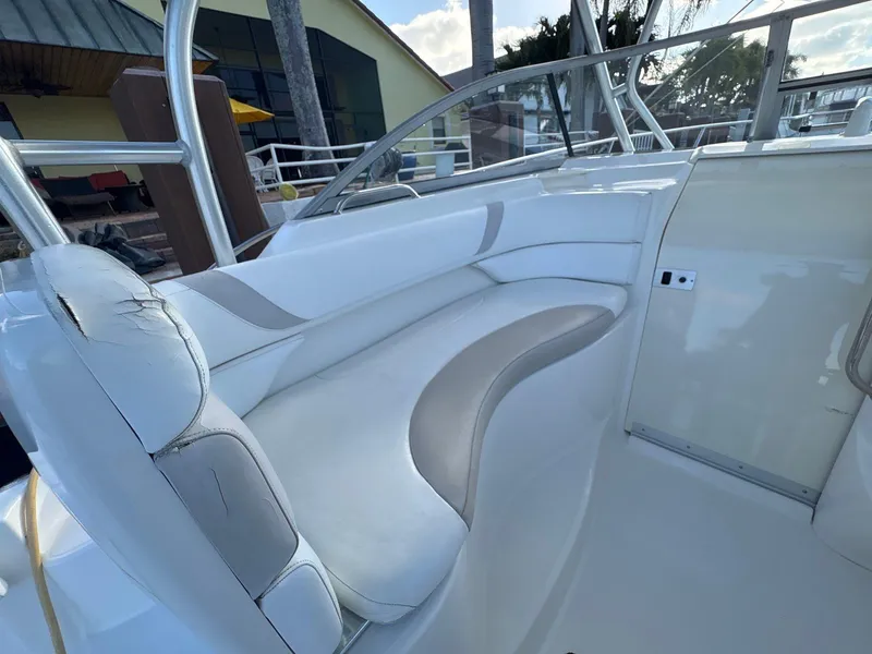 Slide: The Image of 2007 Boston Whaler 305 Conquest interior seating area with white and gray upholstery. - 11