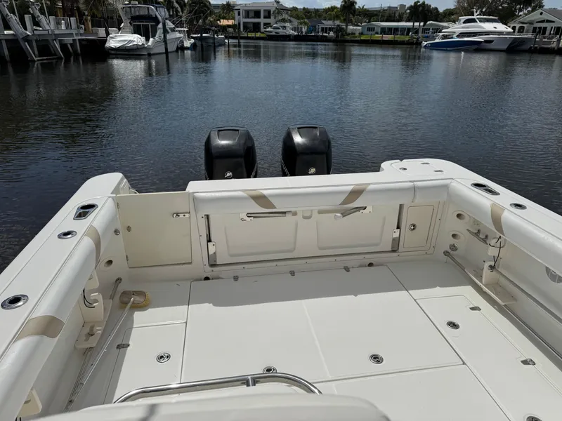 Slide: The Image of 2006 Boston Whaler 305 Conquest boat deck with dual engines, docked in a marina. - 13