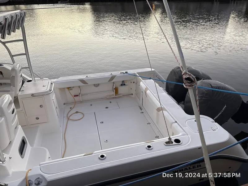 Slide: The Image of 2007 Boston Whaler 305 Conquest boat docked by calm water at sunset. - 14