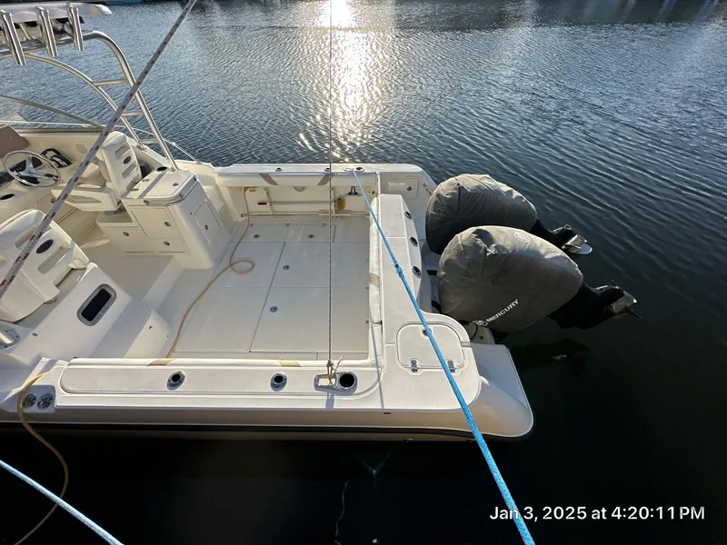 Slide: The Image of 2007 Boston Whaler 305 Conquest docked, featuring dual engines and spacious deck. - 15