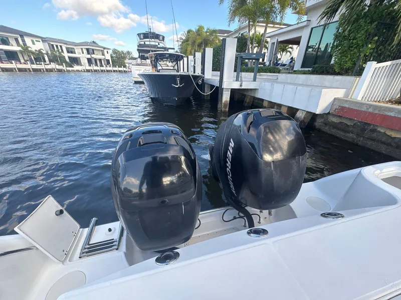 Slide: The Image of 2007 Boston Whaler 305 Conquest with dual Mercury outboard engines docked by waterfront homes. - 17