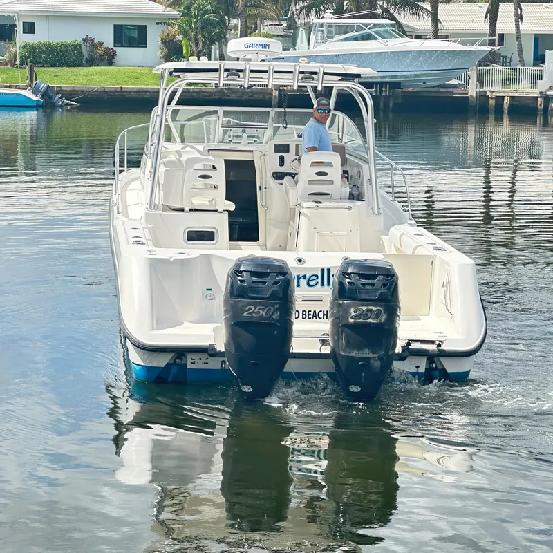 Slide: The Image of 2006 Boston Whaler 305 Conquest boat with dual engines on a calm waterway. - 4