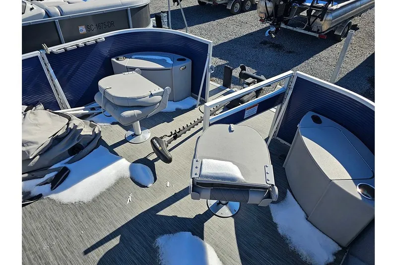 Slide: The Image of 2022 Bennington 22SF pontoon boat interior with snow-covered seats and storage compartments. - 12