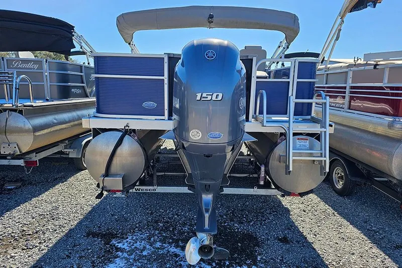 Slide: The Image of 2022 Bennington 22SF pontoon boat with Yamaha 150 outboard motor, parked on gravel. - 6