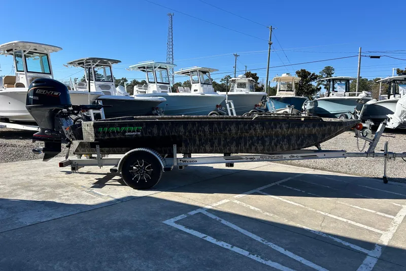 Slide: The Image of 2025 Havoc 1860 Dbst boat on trailer, parked in marina with other boats. - 6