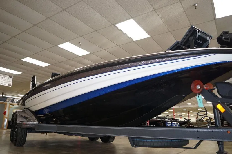 Slide: The Image of 2026 Skeeter FXR20 FLEX boat on trailer in showroom, low-angle view. - 23