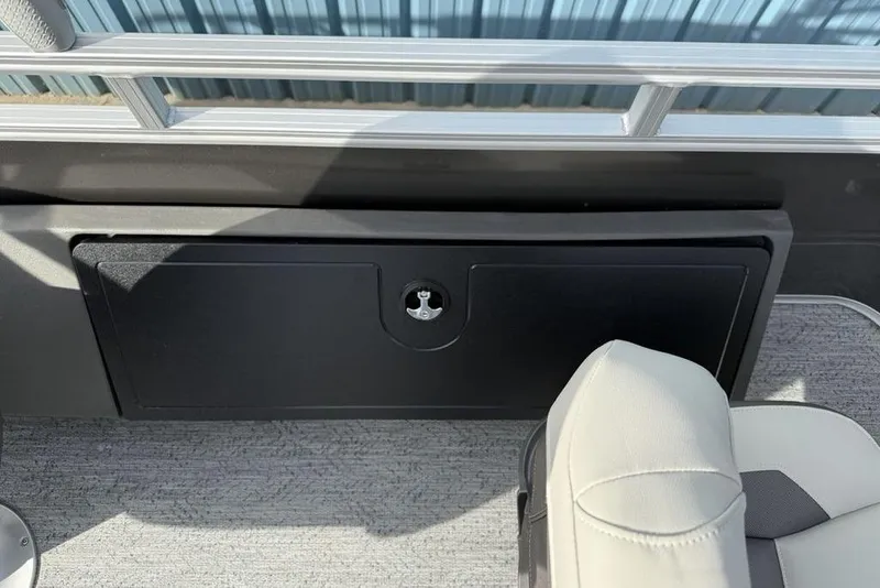 Slide: The Image of 2026 Sun Tracker Fishin' Barge 22 DLX interior storage compartment and seating detail. - 19