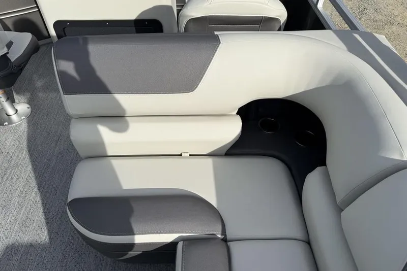 Slide: The Image of 2026 Sun Tracker Fishin' Barge 22 DLX interior seating with cup holders, gray upholstery. - 21