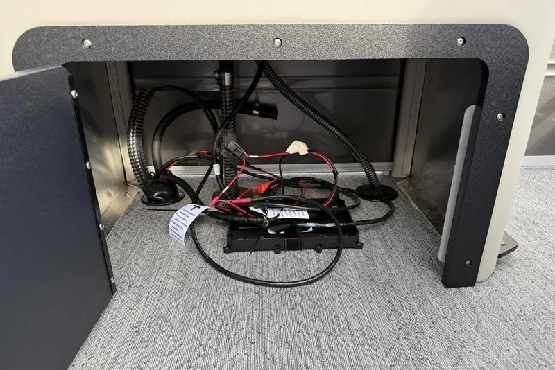 Slide: The Image of 2026 Sun Tracker Fishin' Barge 22 DLX wiring compartment with cables and connectors. - 31