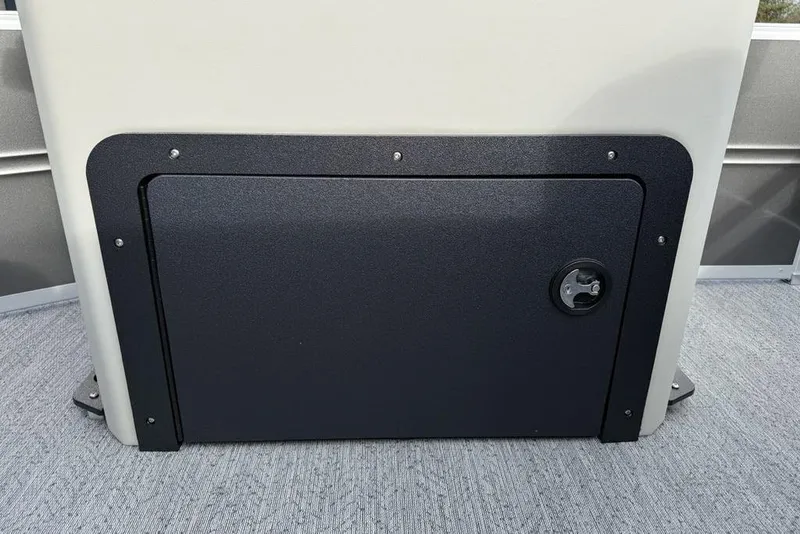 Slide: The Image of 2026 Sun Tracker Fishin' Barge 22 DLX storage compartment with secure latch on deck. - 32