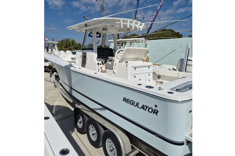 Slide: The Image of 2026 Regulator 31 boat on trailer, displayed outdoors under clear sky. - 17