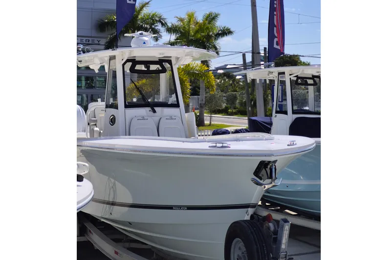 Slide: The Image of 2026 Regulator 31 boat displayed outdoors with palm trees in the background. - 20