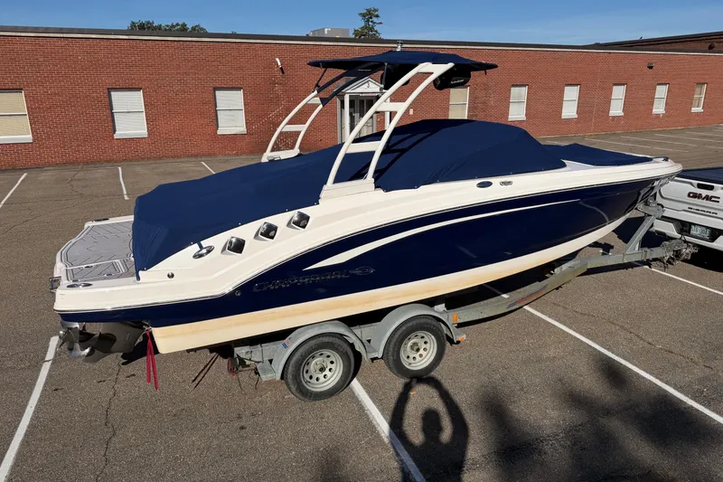 The Image of 2016 Chaparral 246 SSi boat on trailer in parking lot, covered with blue tarp. - 0