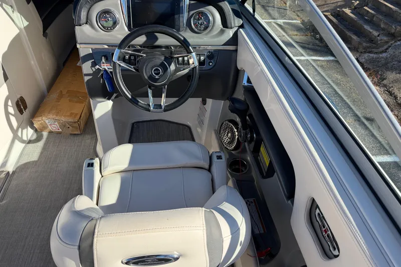 Slide: The Image of 2016 Chaparral 246 SSi boat cockpit with steering wheel and dashboard controls. - 2