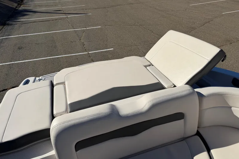 Slide: The Image of 2016 Chaparral 246 SSi boat with adjustable white leather seating in a parking lot. - 5