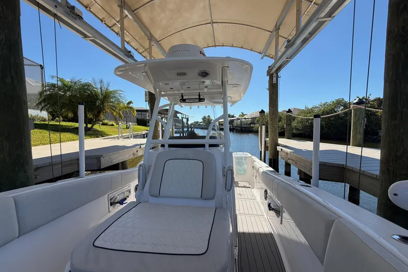 Slide: The Image of 2023 Sea Fox 268 Commander boat docked under canopy, sunny day, waterfront view. - 21