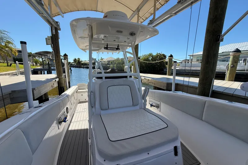 Slide: The Image of 2023 Sea Fox 268 Commander boat interior at a dock, featuring seating and helm station. - 22