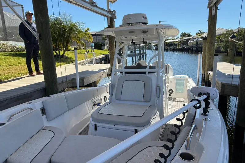 Slide: The Image of 2023 Sea Fox 268 Commander boat docked by a waterfront, showcasing interior seating. - 23