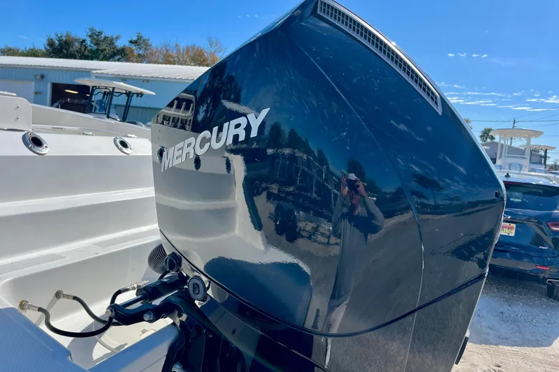 Slide: The Image of 2023 Trophy T24CC boat with Mercury outboard motor in a sunny outdoor setting. - 10