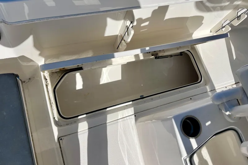 Slide: The Image of 2023 Trophy T24CC boat interior storage compartment with open hatch. - 16