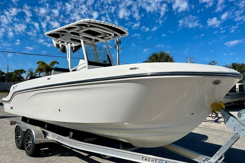 Slide: The Image of 2023 Trophy T24CC boat on trailer under blue sky. - 2