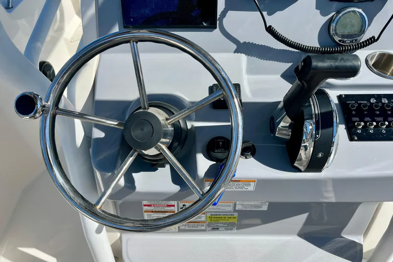 Slide: The Image of Steering wheel and controls of 2023 Trophy T24CC boat cockpit. - 24