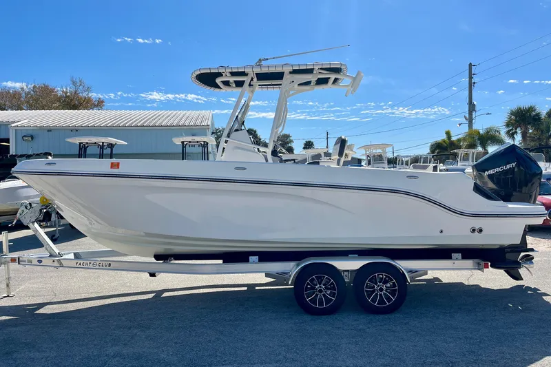Slide: The Image of 2023 Trophy T24CC boat on trailer, side view, outdoors, clear sky. - 5