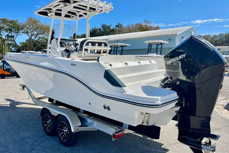 Slide: The Image of 2023 Trophy T24CC boat with Mercury engine on a trailer, parked outdoors. - 6