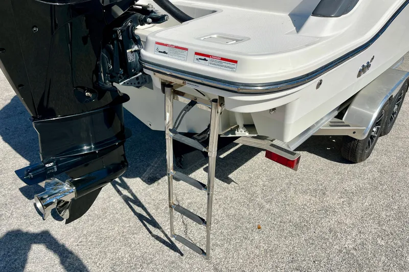 Slide: The Image of 2023 Trophy T24CC boat with ladder and outboard motor on trailer. - 9