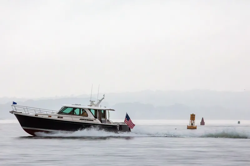 Slide: The Image of 2027 Sabre 45 Salon Express cruising on calm waters with American flag. - 3
