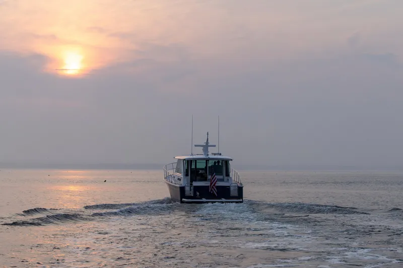 Slide: The Image of 2027 Sabre 45 Salon Express cruising at sunset on calm waters. - 5