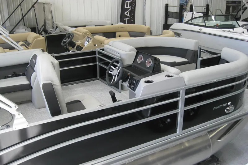 Slide: The Image of 2024 Harris FloteBote Cruiser 210 pontoon boat displayed in showroom. - 2