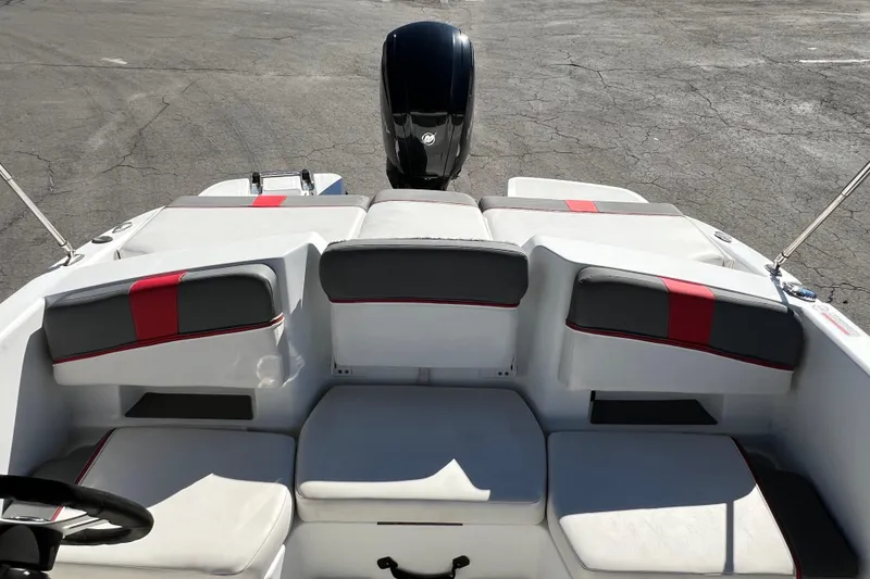 Slide: The Image of 2022 Tahoe T18 boat interior with red and gray seating, outboard motor visible. - 16