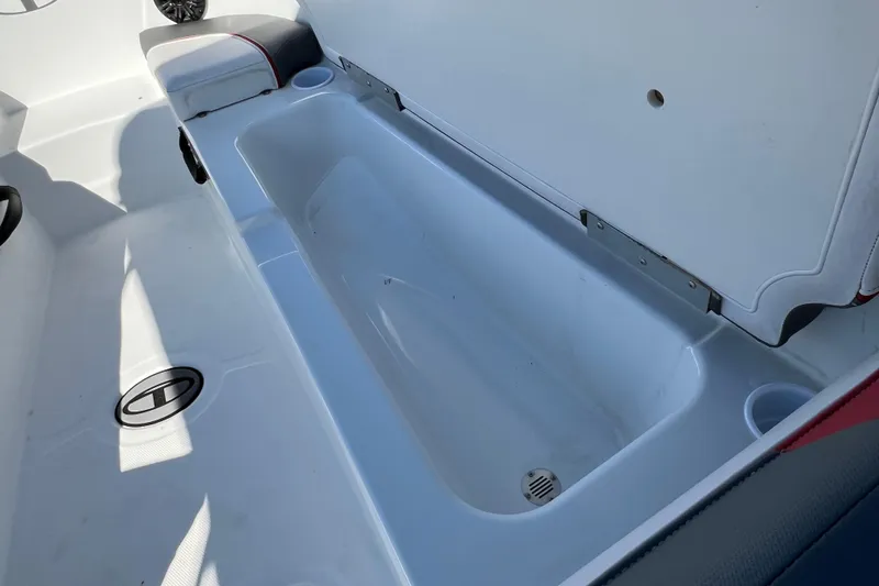 Slide: The Image of 2022 Tahoe T18 boat interior storage compartment with open lid and cup holders. - 18
