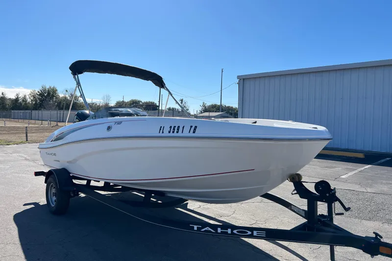 Slide: The Image of 2022 Tahoe T18 boat on trailer, parked outdoors under clear blue sky. - 20
