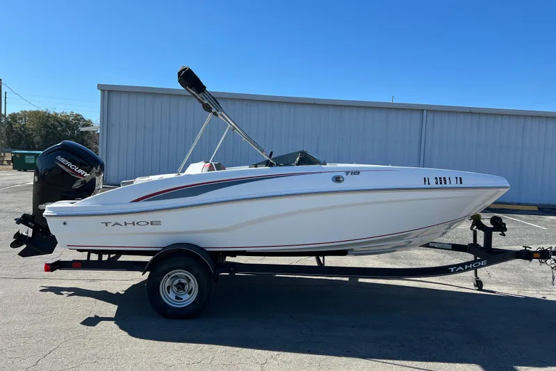 Slide: The Image of 2022 Tahoe T18 boat on trailer with Mercury outboard motor, parked outdoors. - 21