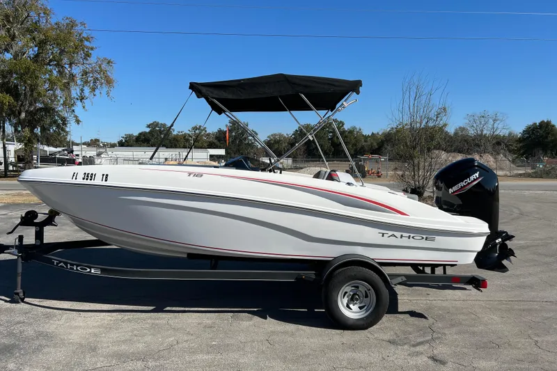 Slide: The Image of 2022 Tahoe T18 boat with Mercury outboard motor on trailer, parked outdoors. - 4