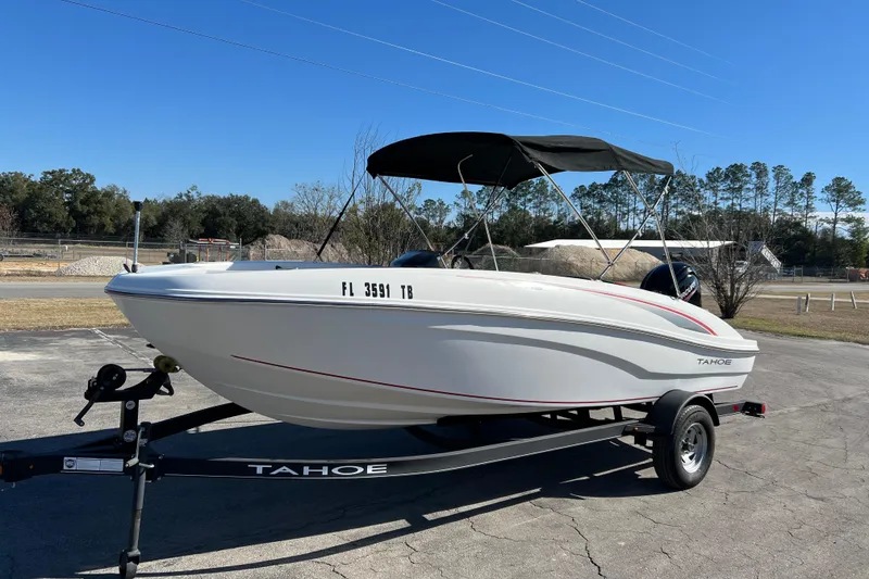 Slide: The Image of 2022 Tahoe T18 boat on trailer, parked outdoors under clear blue sky. - 5