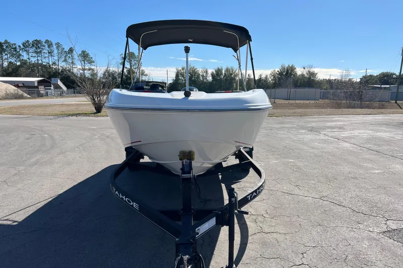 Slide: The Image of 2022 Tahoe T18 boat on trailer, parked outdoors under clear blue sky. - 7